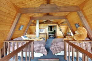 Bedroom featuring vaulted ceiling, carpet flooring, wood walls, and wooden ceiling