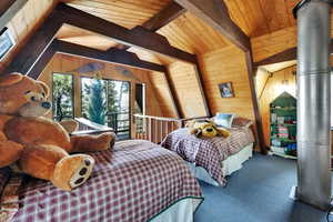 Bedroom featuring wooden walls, wooden ceiling, carpet flooring, and access to outside