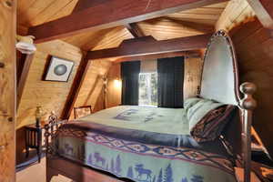 Bedroom featuring wood walls and wooden ceiling
