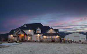 View of front of house featuring a garage, stone siding, and an outdoor structure