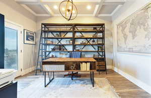 Office area featuring a chandelier, wood finished floors, baseboards, and coffered ceiling