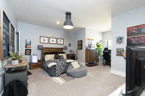 Bedroom with a textured ceiling, baseboards, and carpet floors
