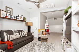 Carpeted living area with recessed lighting, visible vents, and ceiling fan