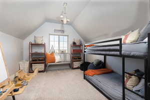 Bedroom featuring carpet flooring and vaulted ceiling