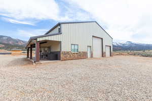 View of outdoor structure featuring a mountain view, an outdoor structure, and gravel driveway