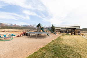 Community playground with a yard and a mountain view