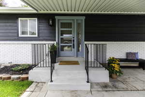Entrance to property featuring brick siding
