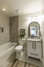 Full bathroom featuring a textured ceiling, tile patterned floors, vanity, and washtub / shower combination
