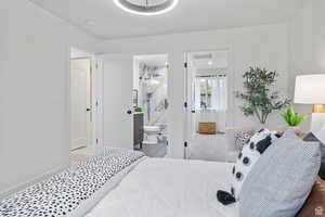 Bedroom with ensuite bath and baseboards