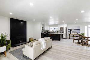 Living room featuring a fireplace, recessed lighting, and light wood-style flooring