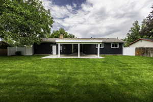 Rear view of house with a fenced backyard, a patio, and a chimney