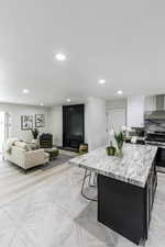 Kitchen with a fireplace, stainless steel range with gas cooktop, recessed lighting, a center island, and white cabinets