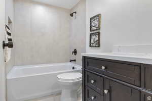 Bathroom featuring vanity, shower / washtub combination, and tile patterned flooring