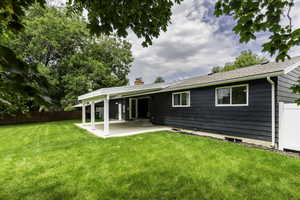 Rear view of house with a patio and a chimney
