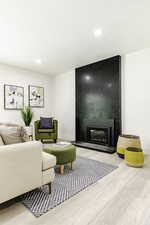 Living room featuring a fireplace, wood finished floors, recessed lighting, and a textured ceiling