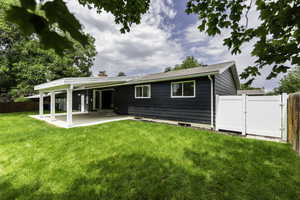 Rear view of property featuring a patio area, a gate, and a chimney