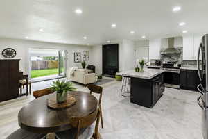 Kitchen featuring stainless steel appliances, dark cabinets, backsplash, a center island, and white cabinets