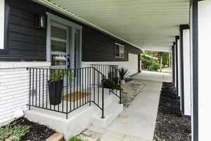 View of exterior entry featuring covered porch