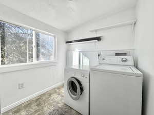 Laundry room featuring washer and dryer and stone finish floors