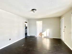 Spare room with wood finished floors and a textured ceiling