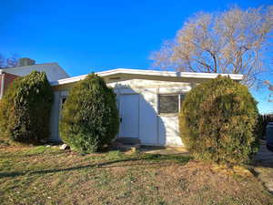 View of side of home featuring a central air condition unit and a yard