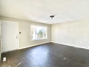 Entrance foyer with a textured ceiling and dark wood-style floors