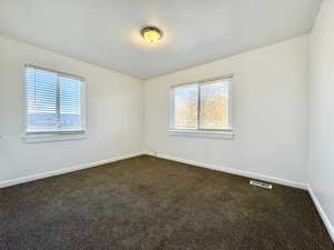 Spare room featuring dark carpet