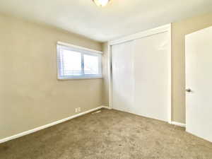 Unfurnished bedroom featuring carpet and a closet