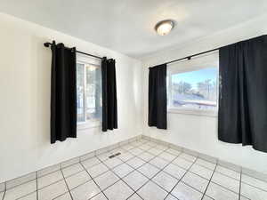 Unfurnished room featuring light tile patterned floors