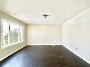 Spare room featuring baseboards and wood finished floors