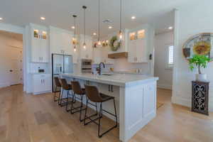 Kitchen with light wood finished floors, white cabinetry, appliances with stainless steel finishes, and recessed lighting