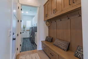 Mudroom with wood finished floors and washer and dryer