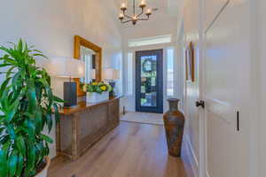 Entrance foyer featuring wood finished floors and a chandelier