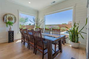 Dining room with wooden walls and light wood finished floors
