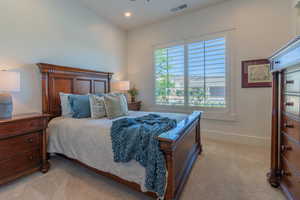 Bedroom with light colored carpet and recessed lighting