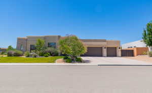 Adobe home with an attached garage, stucco siding, and concrete driveway