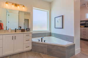 Full bath featuring vanity and a garden tub