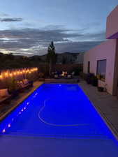 View of pool with a fire pit and a patio