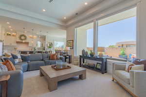 Living area with light carpet and recessed lighting