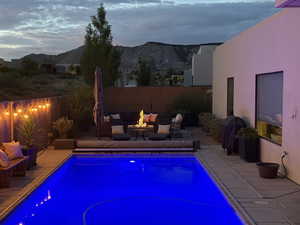 View of pool with a mountain view, a patio area, and an outdoor living space with a fire pit