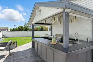 Fenced backyard featuring area for grilling and a patio