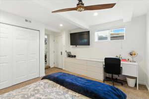 Bedroom featuring beam ceiling, light colored carpet, a ceiling fan, recessed lighting, and built in desk