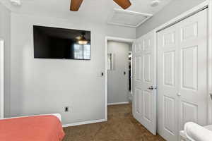 Bedroom with attic access, carpet, a closet, and ceiling fan