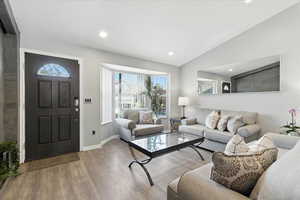 Living area featuring vaulted ceiling, wood finished floors, and recessed lighting