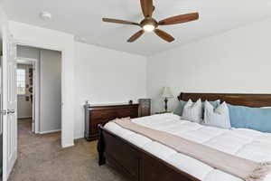 Carpeted bedroom featuring a ceiling fan and baseboards