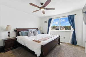 Carpeted bedroom featuring a ceiling fan and baseboards