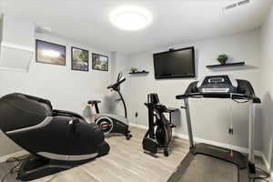 Exercise room featuring wood finished floors and baseboards