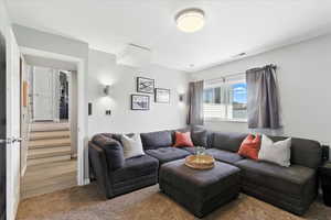 Living room with carpet floors and stairs