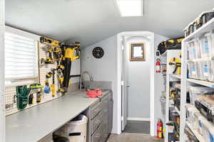 Kitchen featuring concrete floors, lofted ceiling, and light countertops