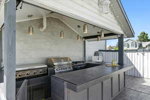 View of patio with exterior kitchen and a sink